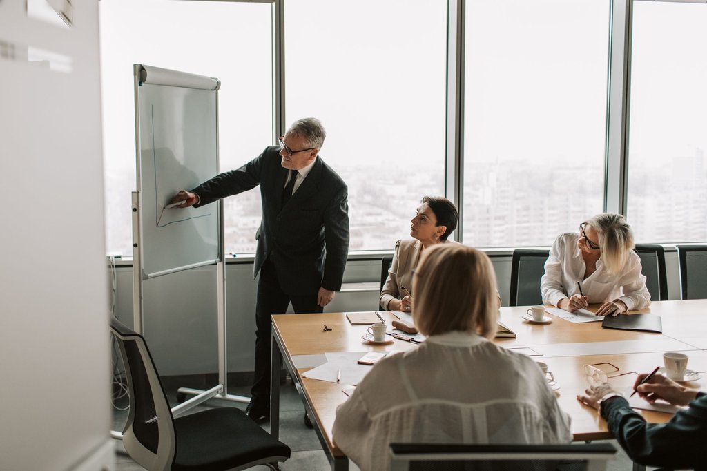 A trainer presenting to colleagues in a conference room during an onboarding session.