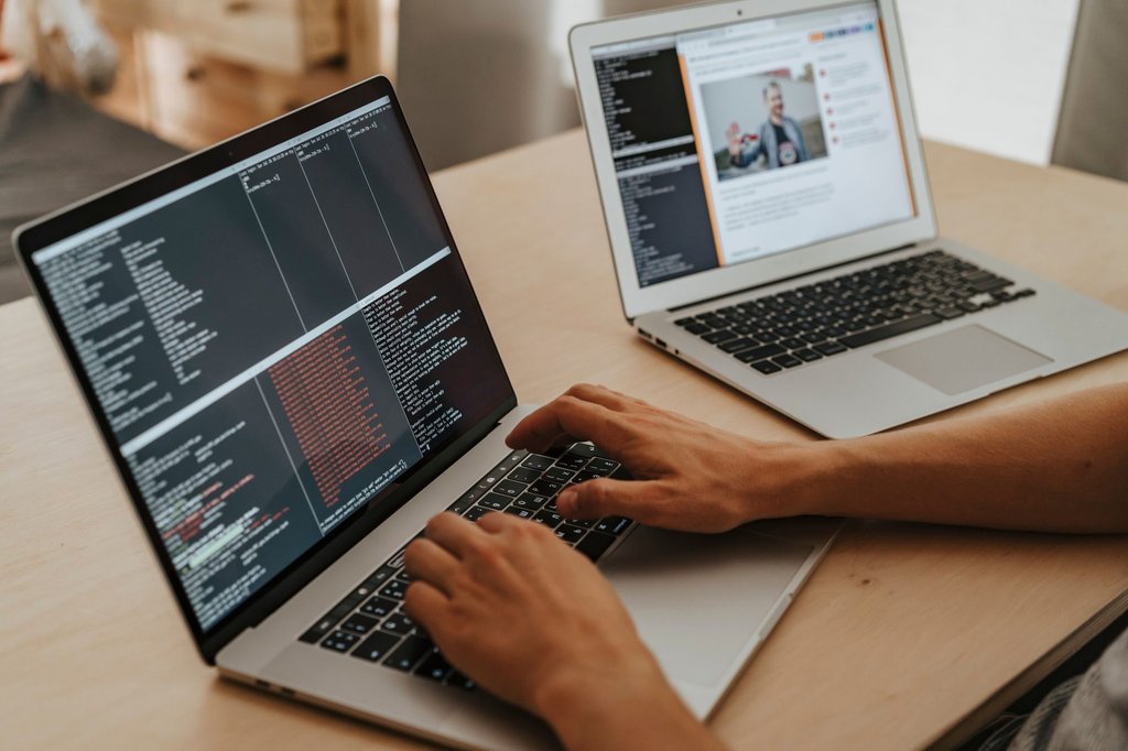 A developer typing code on a laptop while building a custom business app on Zoho Creator.