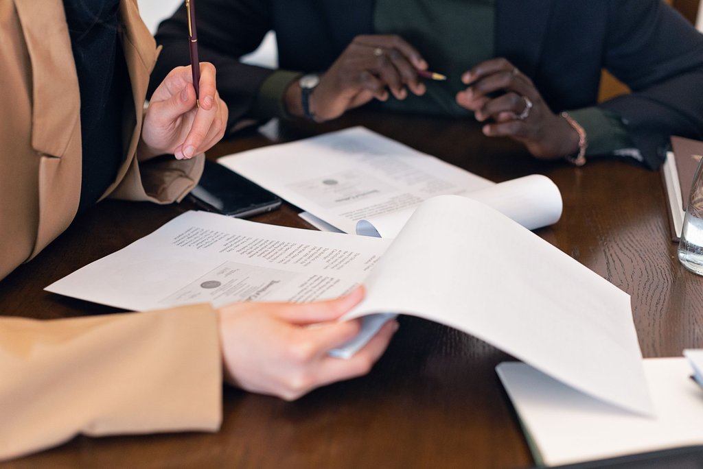 Two people reviewing a printed document together at a table.