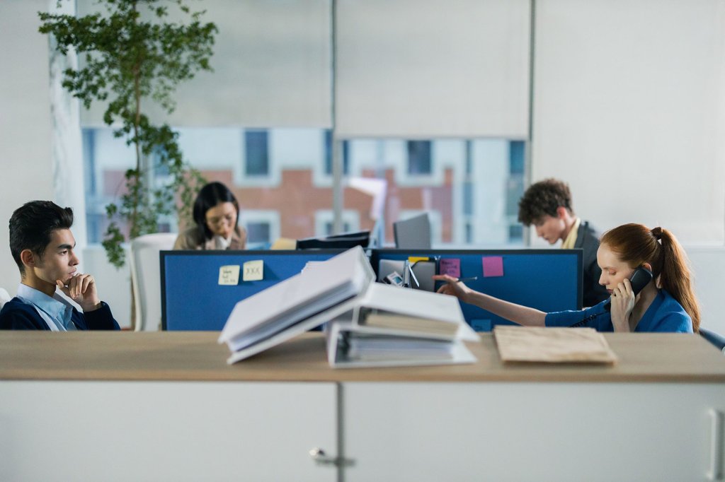 Several people working in a contemporary office, the kind of team that runs day to day on the full Zoho One bundle.