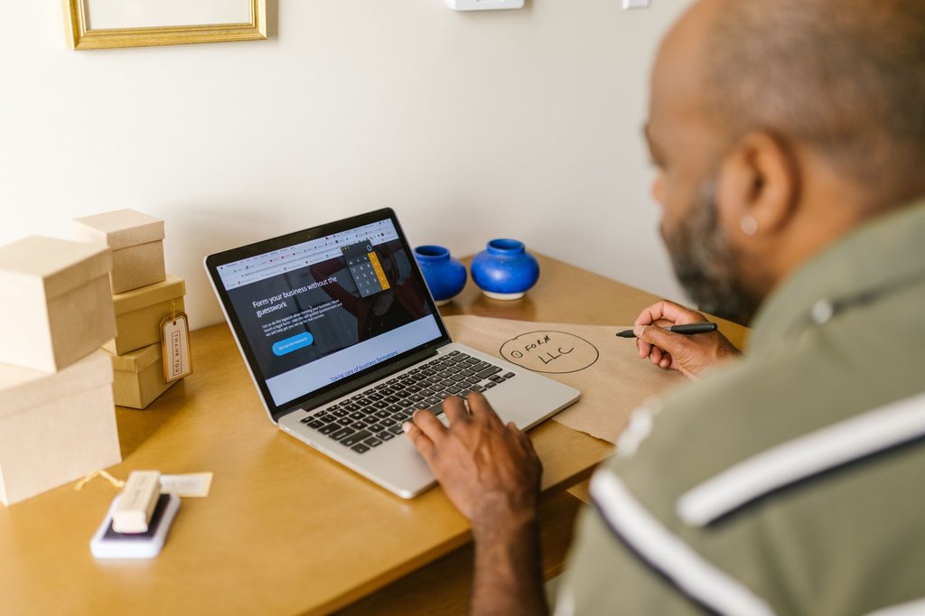 Small business owner working at a computer behind the counter.