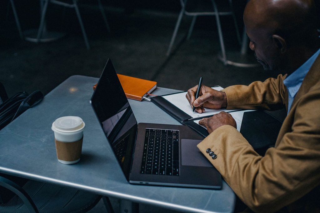 An overhead view of a freelancer with a laptop and handwritten notes, running a solo operation on Zoho One.