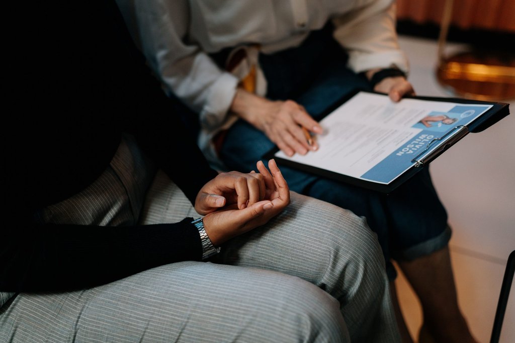 Two HR professionals reviewing a candidate resume together during a hiring round.