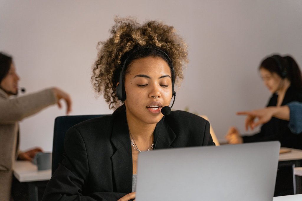A support agent taking a call at a laptop