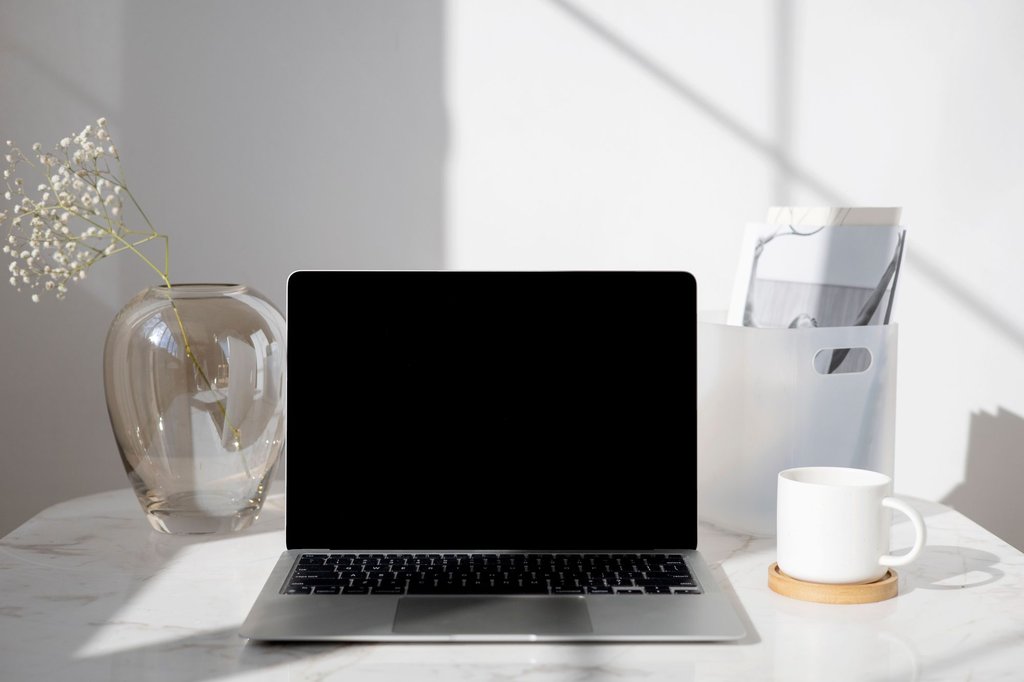 A closed laptop and a cold cup of coffee on a desk nobody has returned to